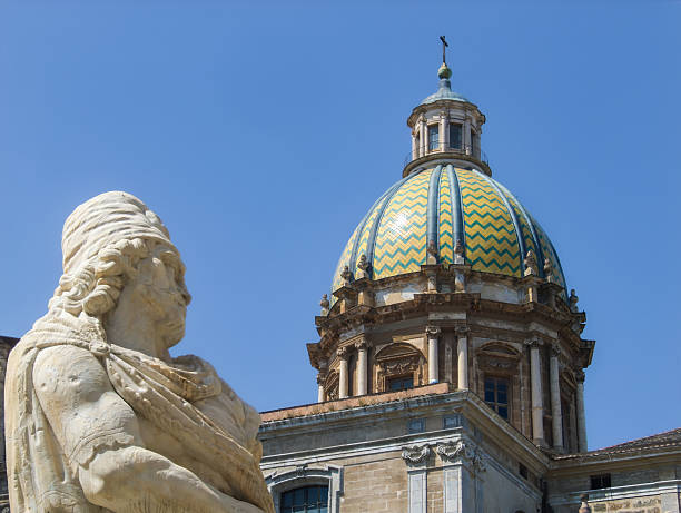 Palermo, Sicily, Italy- May 24, 2009: Marble sculpture close-up with intricate details, set against the vibrant dome of a historic building. Bright blue sky enhances the architectural beauty. Copy space