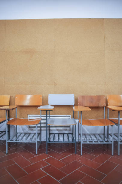 Empty classroom with rows of wooden chairs and desks. The neat layout and clean space reflect a functional, well-organized learning environment.