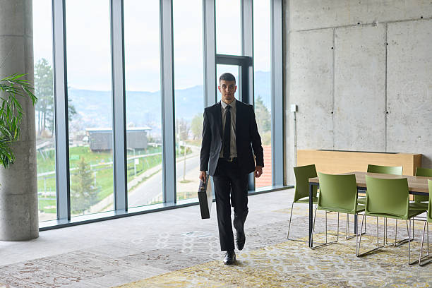 istock A determined businessman in a black suit confidently walks through the office, embodying professionalism and focus as he heads towards new challenges 2206363990
