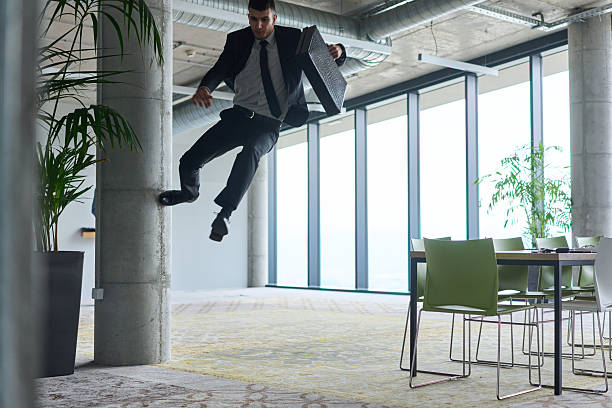 istock A businessman ecstatically jumping in a modern office, holding a briefcase in his hands, celebrating a moment of success and triumph. 2206365314