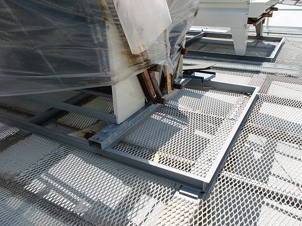 istock A rooftop HVAC unit partially covered in plastic wrap sits on a diamond-patterned metal floor. 2206367917
