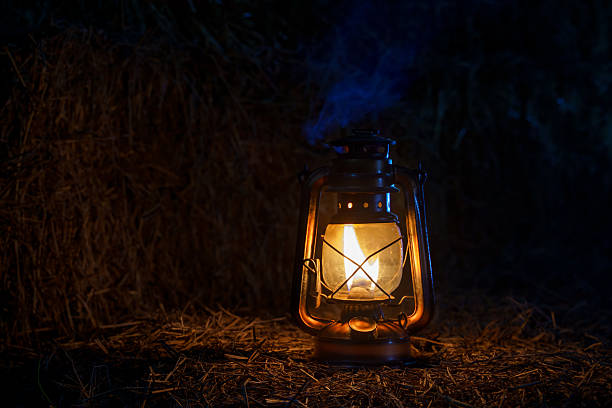 istock antique kerosene lamp with lights on a haystack in a barn at night 2206372398