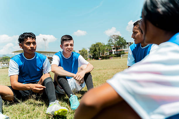 Boys Football Team. Teenage Boys Huddling Together in a Circle on Grass Field. Kids in Sports Team in Building Team Spirit Before The Soccer Game
