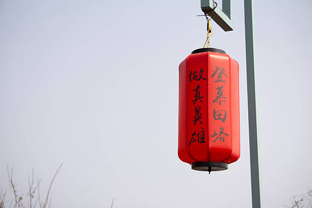 istock A vibrant red Chinese lantern with calligraphy hangs serenely, contrasting against the pale sky at the Great Wall of China 2206373786