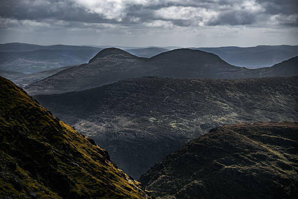 istock Dark, rugged mountains create a striking silhouette as the sun casts shadows over the valleys. The scene captures the breathtaking beauty of nature during the late afternoon. 2206378481