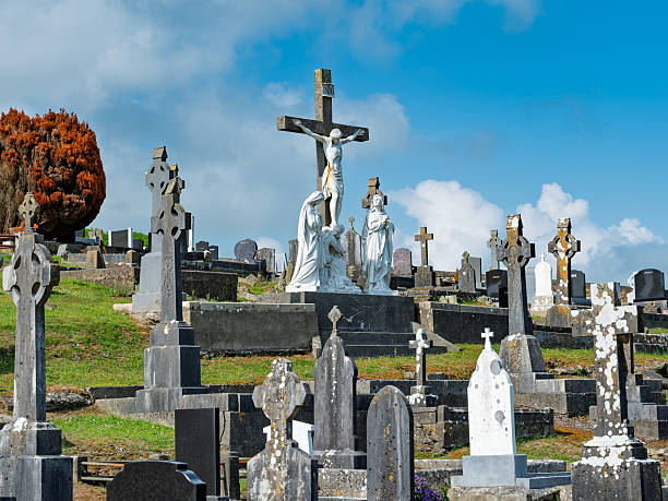 Galway, Ireland - September 1, 2018 - A photo of traditional Celtic crosses and decorative tombstones marking graves under a cloudy sky in a cemetery near Galway, Ireland, on an Autumn afternoon.
