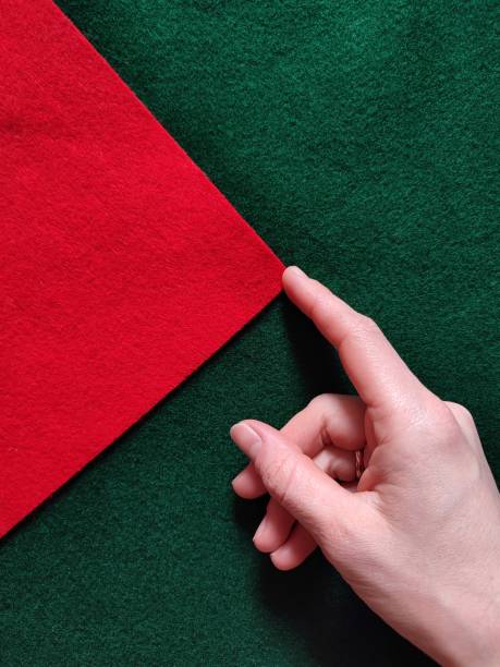 istock Touching the edge of red felt on green fabric background 2206382661
