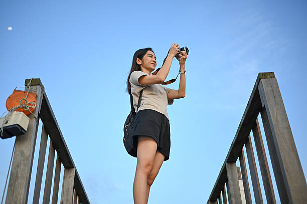With camera in hand, she roams the docks, immortalizing the tranquil sunset moments of the fishing village