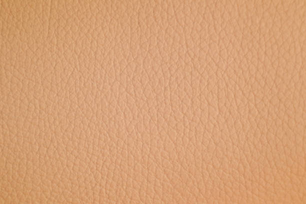 istock Light peach leather texture. Gentle and textured Peach Fuzz background 2206384536