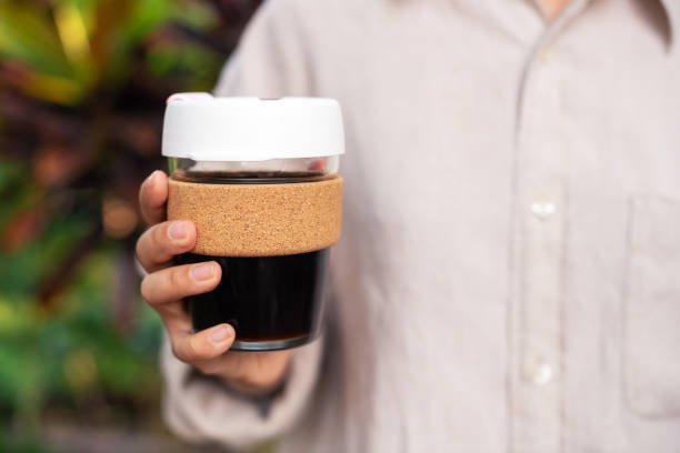 istock Female hands holding reusable coffee cup in the nature background. 2206386429