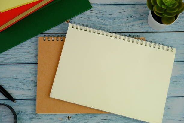 istock flat lay of a blank note book for text space. Educational and financial concept with text space on green background. surrounded by office tools. 2206387741
