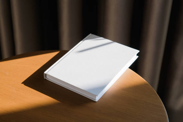 istock blank book mockup on wooden coffee table , shadow overlay 2206388833