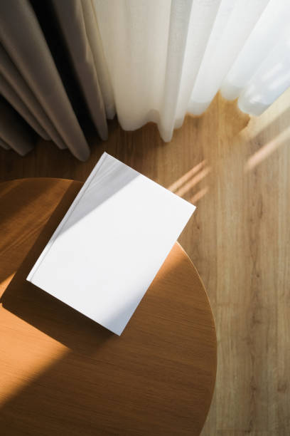 istock blank book mockup on wooden coffee table , shadow overlay 2206388977