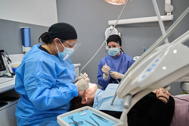 istock Dentist performing dental procedure on patient with assistant 2206393325