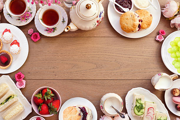 istock Afternoon tea frame against a light brown wood banner background 2206395275