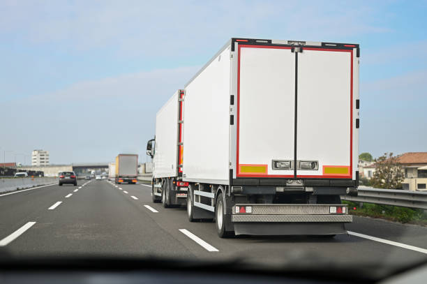 istock White trucks transporting goods on a highway during the day 2206396953