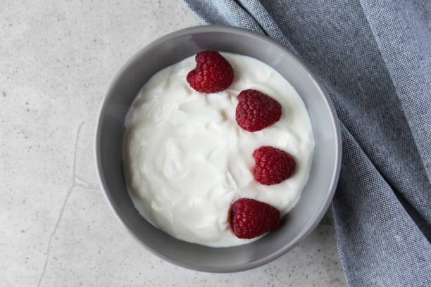 istock Gray bowl and natural yogurt with berries on the stone marble table. 2206401218