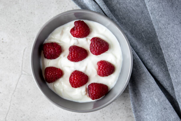 istock Gray bowl and natural yogurt with berries on the stone marble table. 2206401243