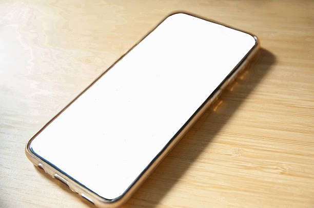 istock Mobile white screen resting on a wooden table 2206404588