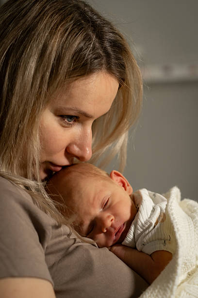 istock Mom lovingly cradles her sleeping baby in a cozy indoor setting during a quiet afternoon 2206405213