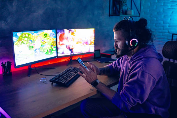 istock Man using mobile phone while playing games in room with neon lighting 2206406645