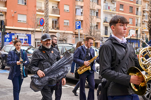 Band members walking and playing musical instruments during the fallas 2025 parade in valencia, spain