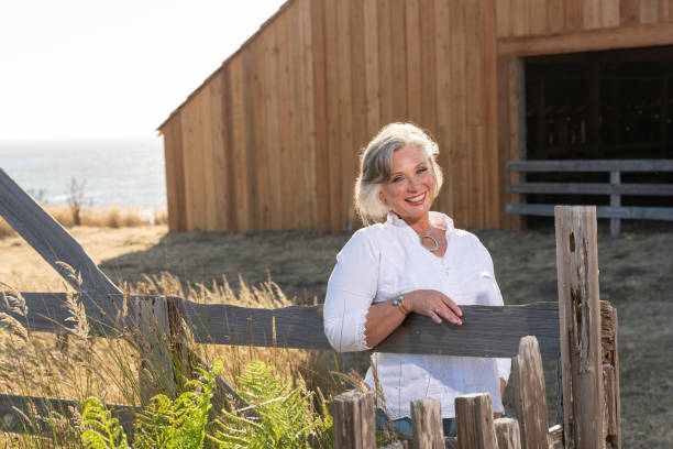 istock Middle age woman posing outdoors by barn. Professional model. 2206409873