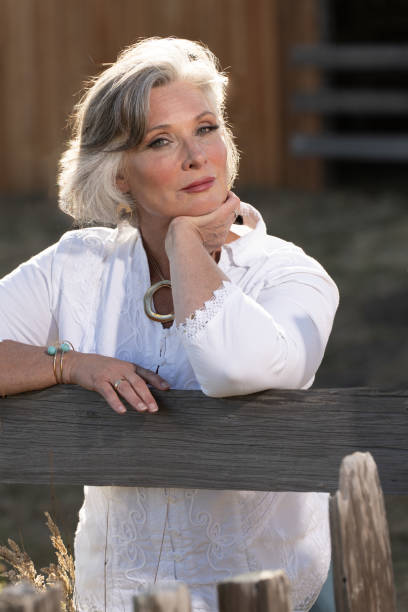 istock Middle age woman posing outdoors by barn. Professional model. 2206409887