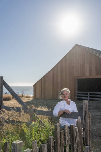 istock Middle age woman posing outdoors by barn. Professional model. 2206409897