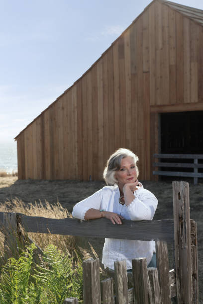 istock Middle age woman posing outdoors by barn. Professional model. 2206409914