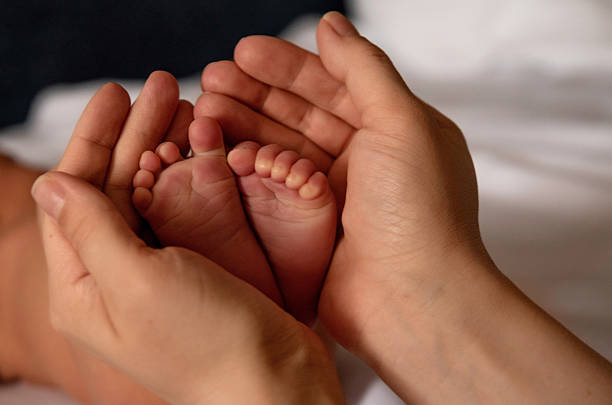 istock Mother holding newborn baby's legs 2206412791