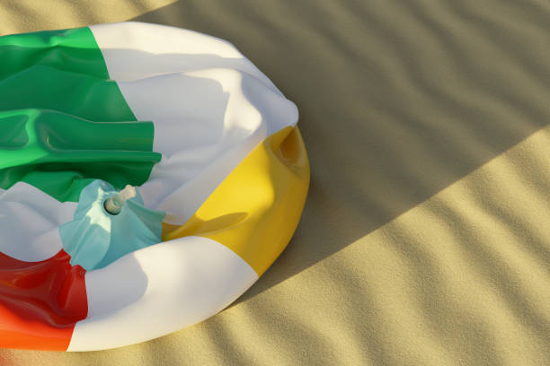Deflated beach ball lying on wavy sand during sunset. 3d illustration, realistic render. Copy space