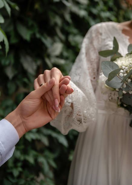 Wedding couple holding hands, close-up