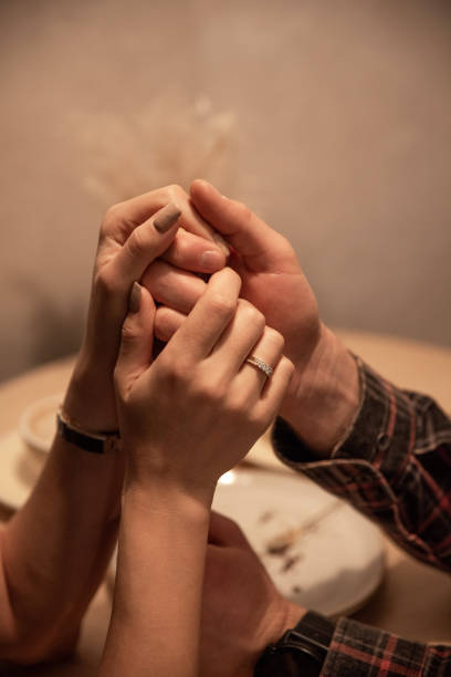 Close up of couple's hands with engagement rings
