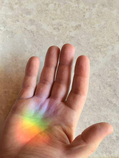 istock Holding a rainbow - hand with a rainbow spot 2206417518