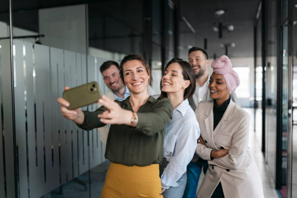istock Happy business team taking a selfie in the office hallway 2206419011