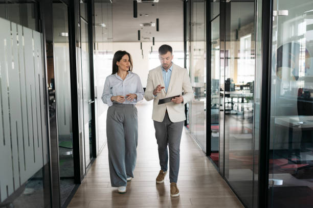 istock Businesspeople walking and talking in modern office corridor 2206419012
