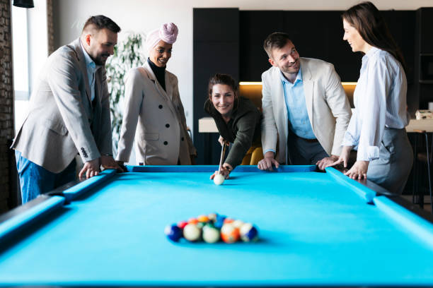 istock Business colleagues playing pool during a break in the office 2206420289