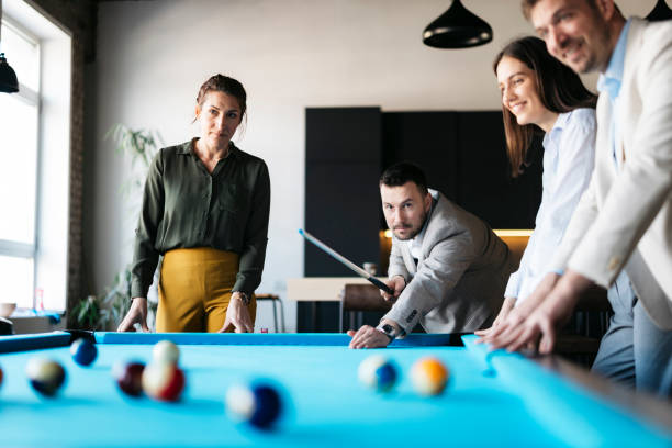 Business colleagues playing pool during a break in the office