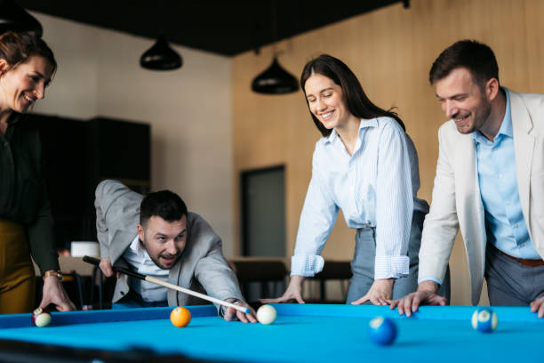 istock Business colleagues playing pool during a break in the office 2206420640