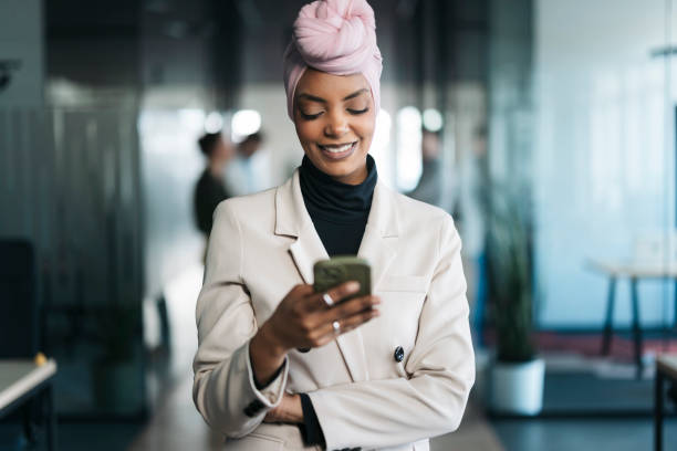 istock Smiling businesswoman wearing hijab using smartphone in modern office 2206420836