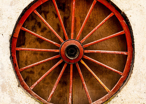 Wheel of very old weathered and worn out wagon once used in farming and ranching in rugged Montana in western USA of North America. The nearest cities are Great Falls, Helena, Bozeman, and Billings Montana.