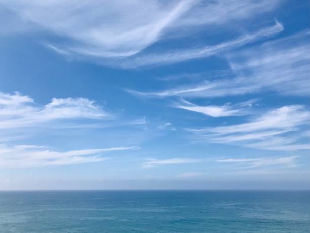 istock A serene seascape vast expanse ocean blends harmoniously into a bright horizon blue sky airy wispy cirrus clouds scattered above. 2206423459