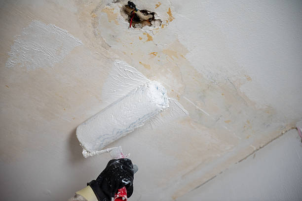 istock Painting damaged ceiling with roller brush. 2206424946
