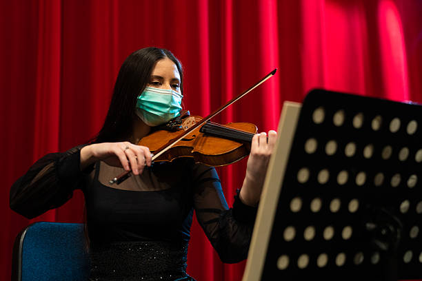 istock Violinist with a mask Rehearsing in Theater 2206424986