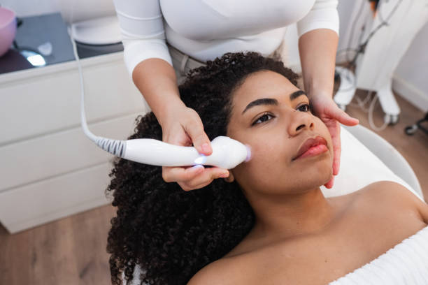 istock Beautician using ultrasound machine on client's face for skin rejuvenation 2206426474