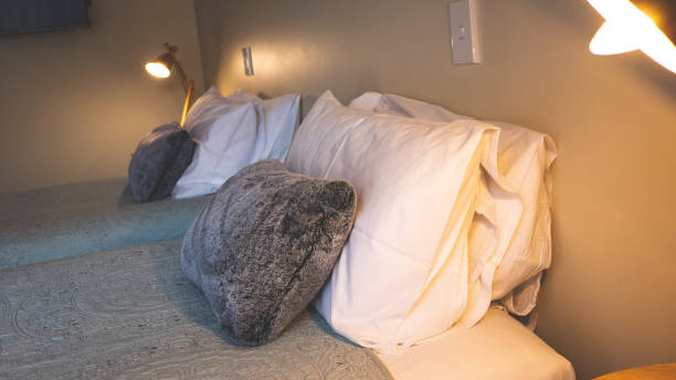 istock Bedroom hotel room interior bed double single luxury bedding folded towels simple tidy clean cushions pillows 2206428908