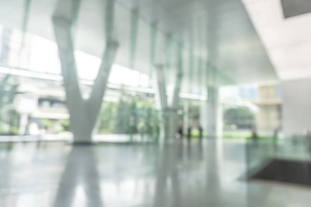 istock Blurred business office building lobby or hotel blur background interior view toward reception hall, modern luxury lounge, white room space with blurry corridor and glass wall 2206429388