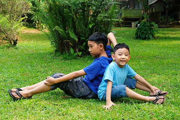Elementary age poor children hugging together outdoor in nature