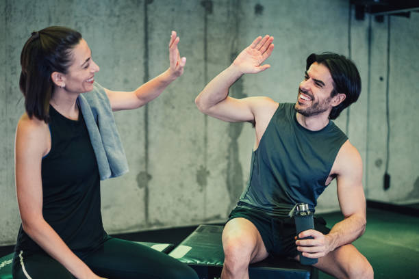 istock Couple giving each other high five after a successful workout in a gym. 2206437322